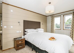 Ein Schlafzimmer mit Bett, Nachttisch und einem fenster mit Vorhängen.
