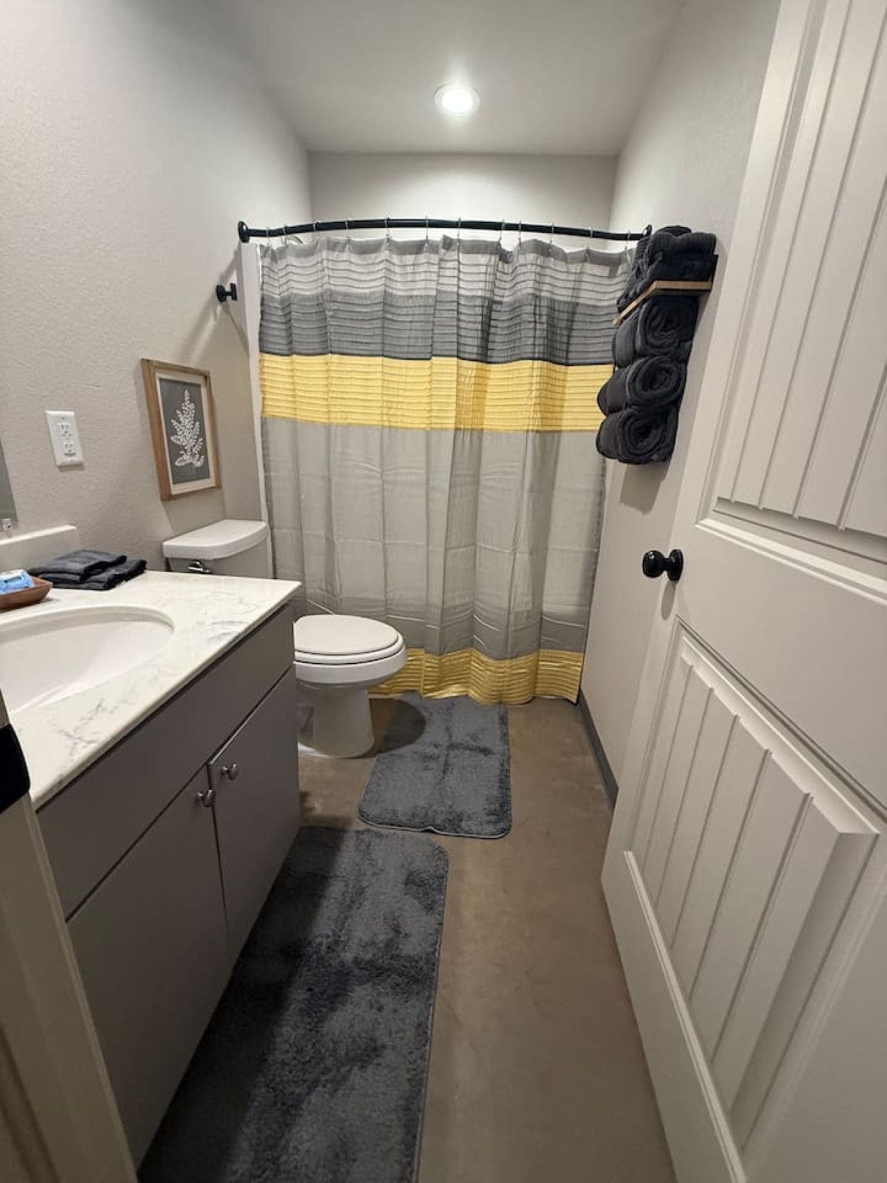 Un baño pequeño con inodoro, lavamanos y cortina de ducha.