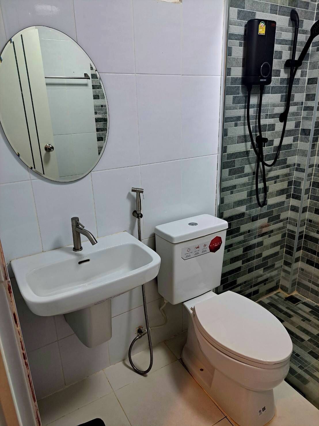 Ein Badezimmer mit Waschbecken, Toilette und Duschbereich.