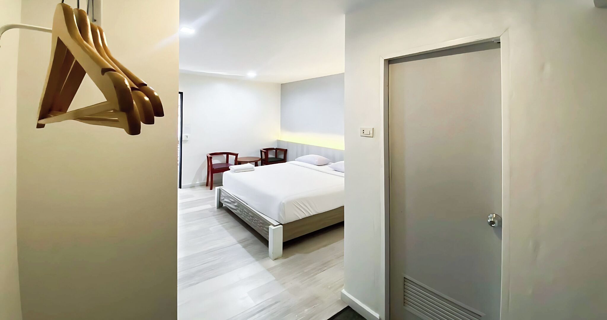 Une chambre d’hôtel moderne, équipée d’un lit, de tables de chevet et d’une armoire.