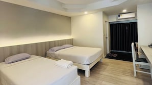 Een hotelkamer met twee bedden, een bureau en een stoel.
