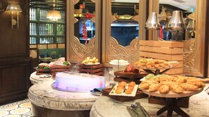Un buffet proposant une variété de plats, une table en marbre et un éclairage décoratif.