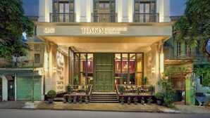 Un immeuble à plusieurs étages doté d’une entrée imposante, de balcons et d’une enseigne indiquant qu’il s’agit d’un hôtel-boutique de luxe avec spa.