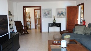 A living room with a television, a sofa, a coffee table, and a bookshelf. - Tranquil Mallorca Villa Seaside Getaway with Pool (IB)