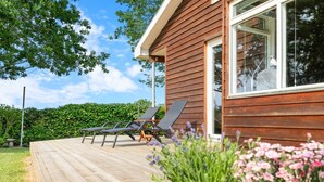 A wooden deck with lounge chairs and a potted plant with flowers. - "Swipdagh" - 150m from the sea by Interhome (Martofte)
