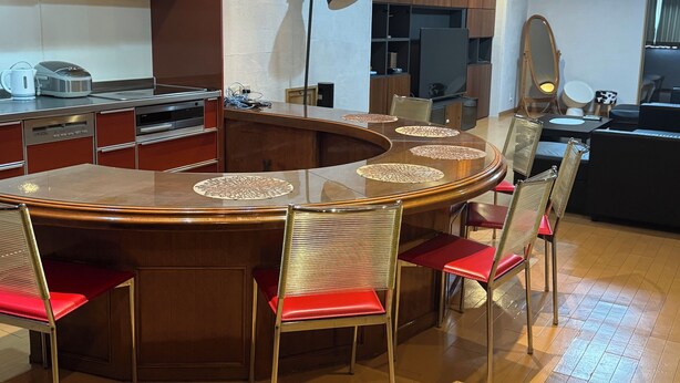 Une cuisine moderne dotée d’un îlot central, d’appareils  électroménagers intégrés et d’un coin repas avec une table ronde et des chaises.
