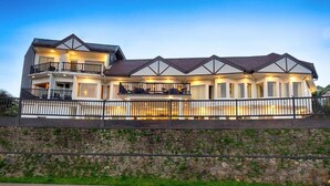 A two-story house with a balcony, a stone wall, and a paved driveway. - Eden Hill Hotel (Nuwara Eliya)