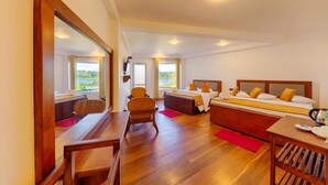 A spacious bedroom with a large bed, a desk, and a chair. There are two windows providing a view of the outdoors. - Eden Hill Hotel (Nuwara Eliya)