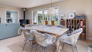 A cozy living room with a fireplace, a dining table with chairs, a sofa, and a bookshelf. - "Nis" - 250m from the sea by Interhome (Brenderup Fyn)