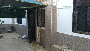 Ein Wohngebäude mit Ziegelverkleidung, einem schwarzen Metallgitter und einem kleinen Fenster mit Metallgitter.