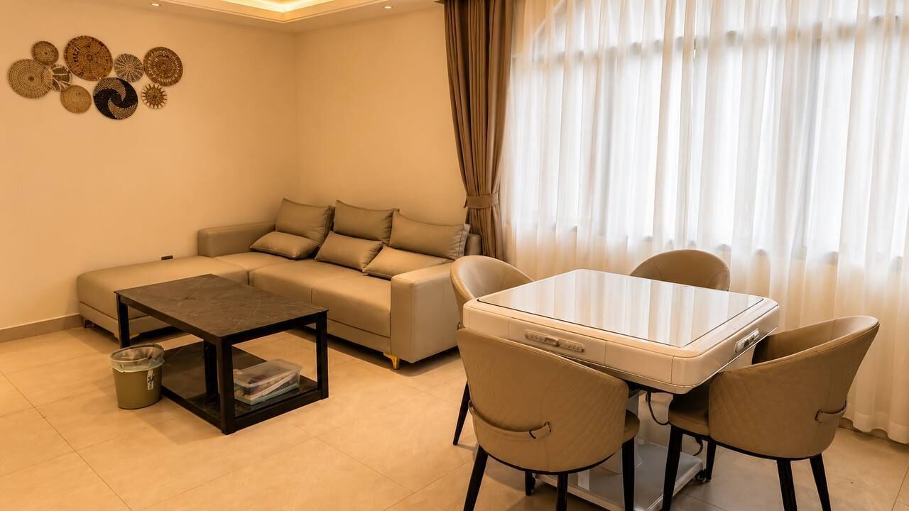 A living room with a sofa, a coffee table, and a dining table with chairs.