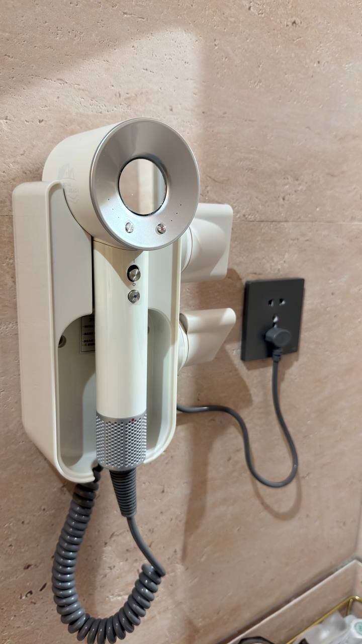 A wall-mounted telephone with a cord, a power outlet, and a wall socket.