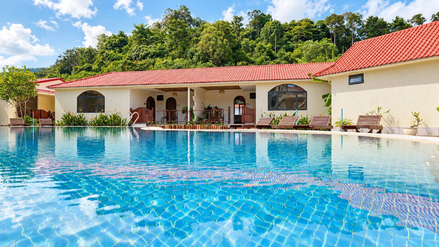 Una piscina con techo de tejas rojas, rodeada de sillas de descanso y un edificio con ventanas de arco.
