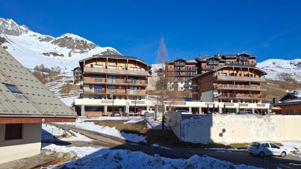 Ein Hotel mit mehreren Stockwerken, Außenbereich und Blick auf schneebedeckte Berge.