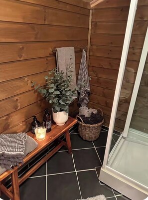 A wooden cabin with a bench, a potted plant, a candle, and a basket of items. - Sunny cabin at Gautefall (Treungen)