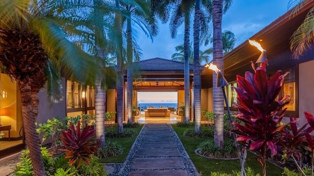 A pathway leading to a covered outdoor seating area with a view of the ocean. - Laueki 5 – Ocean View Estate | Onsite Staff & Daily Housekeeping (Kailua Kona)