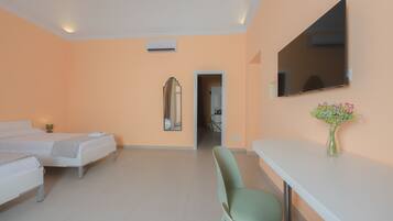 A hotel room with two beds, a desk, a chair, a mirror, and a TV.