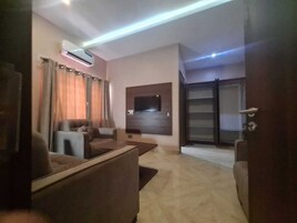 Una sala de estar moderna con un televisor de pantalla plana montado en la pared, un sofá y una mesa de centro.