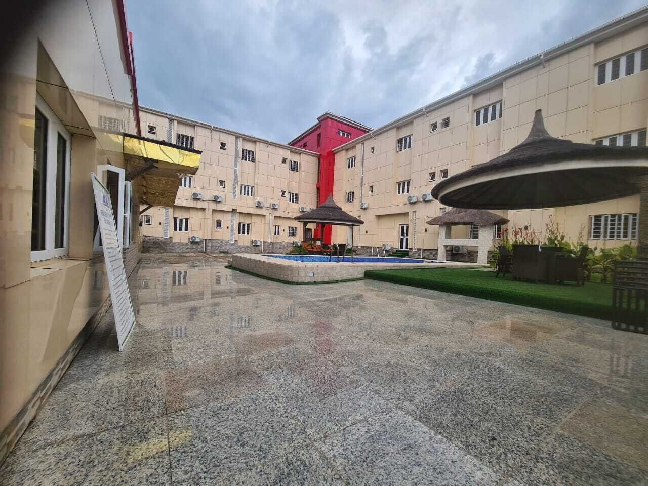 Un cortile con fontana centrale, circondato da edifici dall'architettura uniforme.