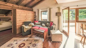 A cozy room with wooden beams, a sofa, a coffee table, and a patterned rug.