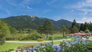 A park with a lake, picnic areas, and a mountain backdrop.