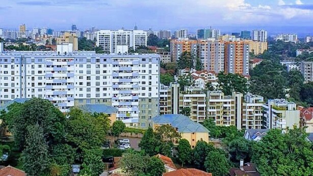 Un quartier résidentiel composé d’immeubles d’habitation à plusieurs étages, entouré de verdure et d’arbres.