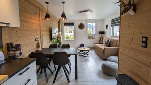 A modern living room with a wooden wall, a sofa, a coffee table, and a mounted deer head.