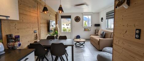 Een moderne woonkamer met een houten wand, een bank, een salontafel en een opgehangen hert.