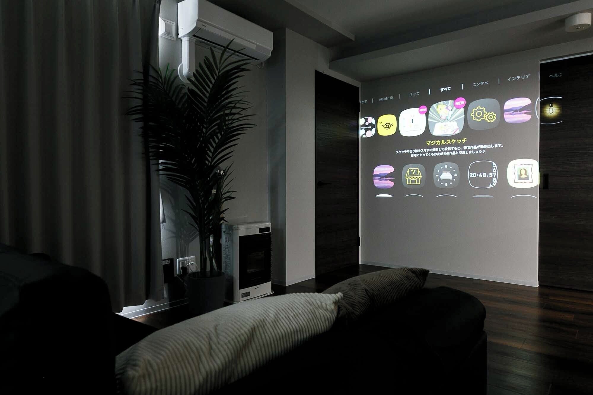 A modern living room with a large projection screen displaying various icons.