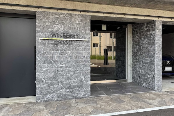 A building entrance with a marble facade and a sign reading "TWINBERRY CHITOSE". - Twinberry CHITOSE (Chitose)