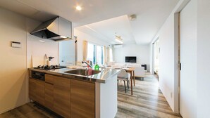 Cocina moderna con isla central, horno empotrado y electrodomésticos de acero inoxidable.