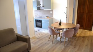 Un salon moderne avec un canapé et une table à manger entourée de chaises.