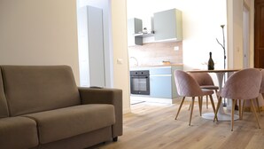 Un salon moderne avec un canapé et un coin repas doté de chaises roses.