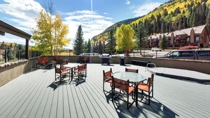 A wooden deck with outdoor seating, overlooking a mountainous area with autumn foliage. - Gorgeous Mountain Condo Near Purgatory Ski Resort (Durango)