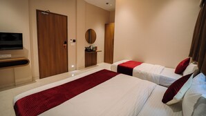 A hotel room with two beds, a TV, a mirror, and a wardrobe. - Ascent Star Inn (Mumbai)