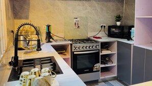Una cocina moderna con armarios grises, estufa integrada y una pequeña isla con un plato de comida.