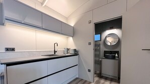 Eine moderne Küche mit grauen Schränken, einer schwarzen Arbeitsplatte und einem eingebauten Backofen.