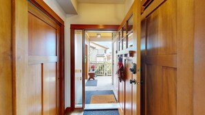 Un couloir en bois mène à un balcon d’où l’on peut admirer les maisons voisines.