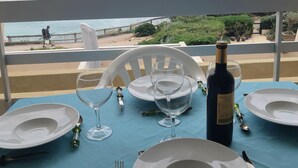 A table set for dining with a view of the sea, a bottle of wine, and a chair. - Exceptional view of the sea from the popular Corniche district (Sète)
