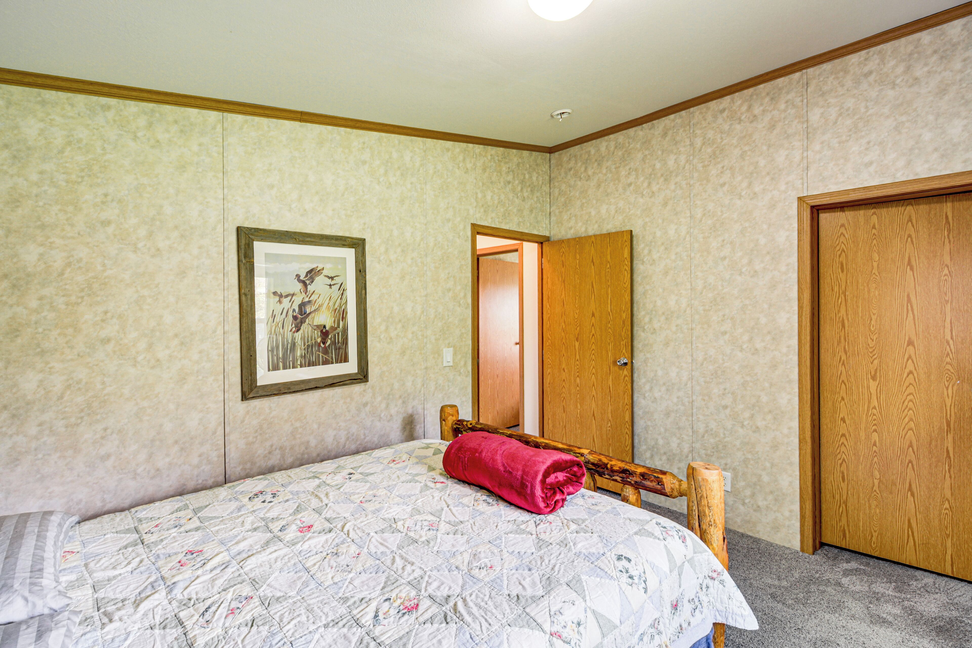 Una camera da letto con un letto, una porta e un quadro appeso al muro.