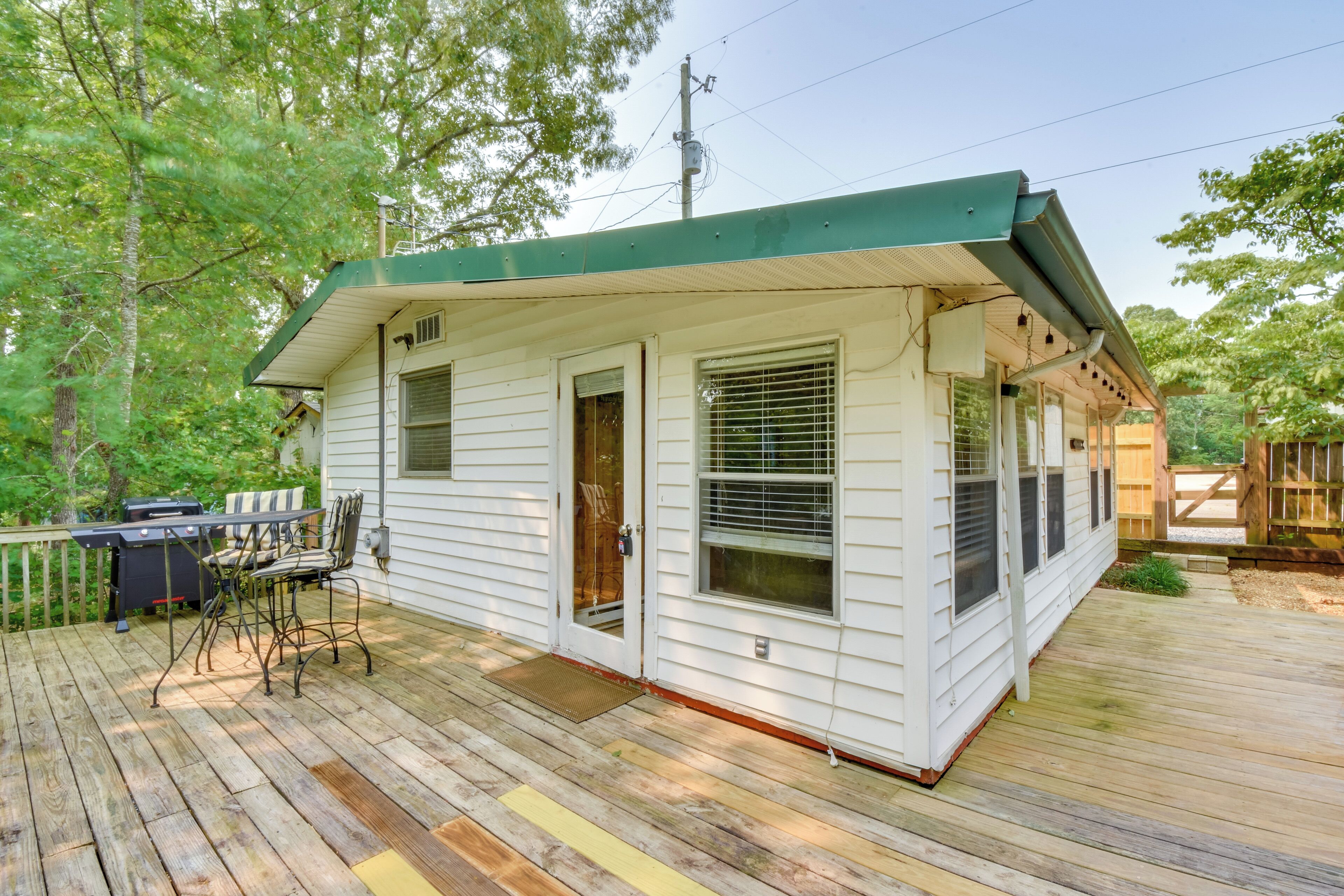 A single-story house with a covered porch, a grill, and outdoor seating.