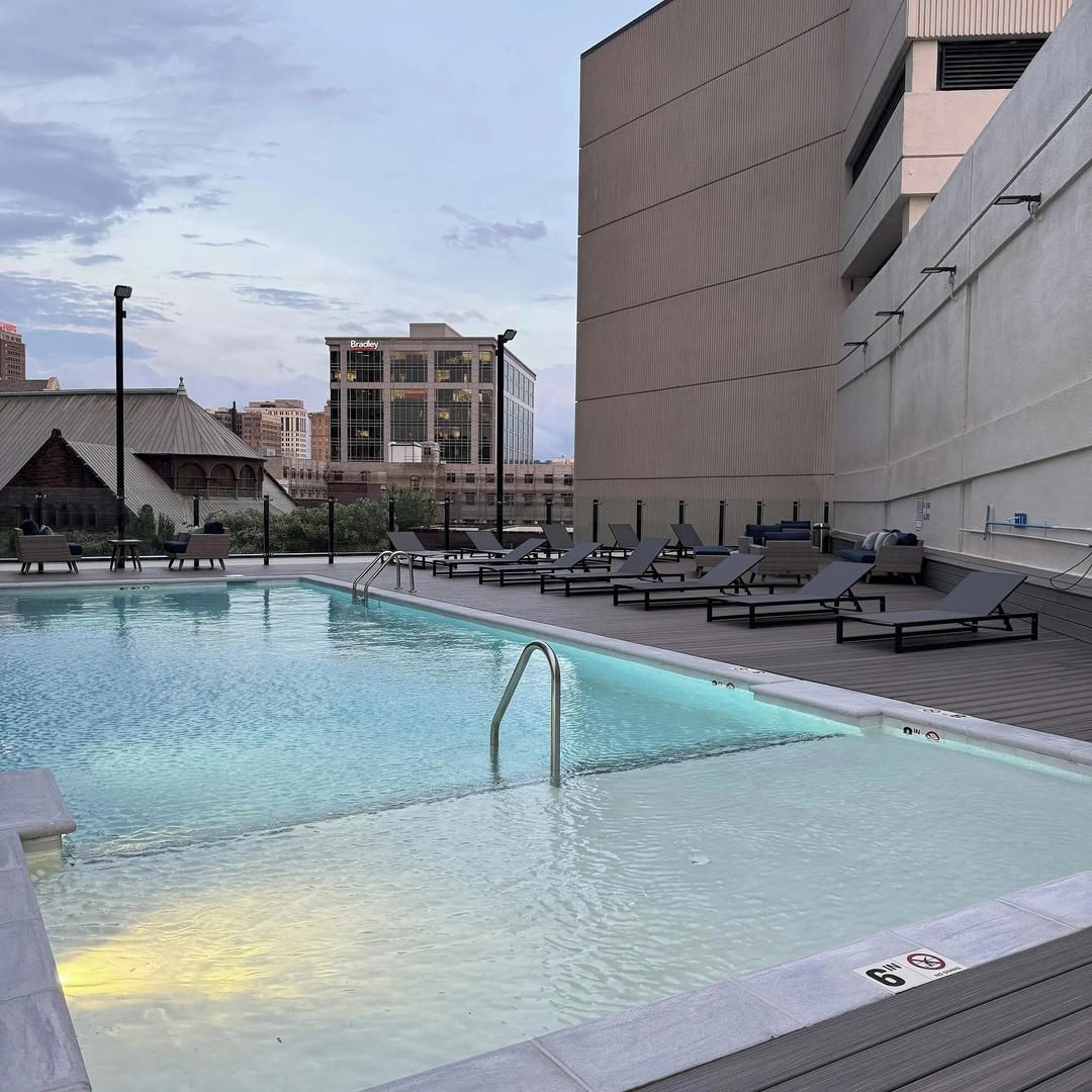Una piscina sul tetto con poltrona a sdraio e vista sulla città.