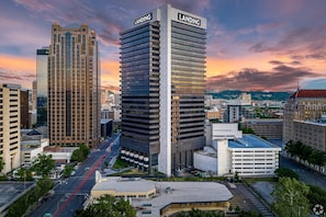 A cityscape with modern high-rise buildings, including a prominent 'LANDING' building, and a well-maintained urban street.
