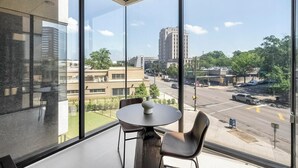 A modern hotel room with large windows offering a city view. - Landing | Incredible 1BD in Fountain Heights (Birmingham)