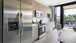 Una cocina moderna con electrodom ésticos de acero inoxidable, horno empotrado y microondas.