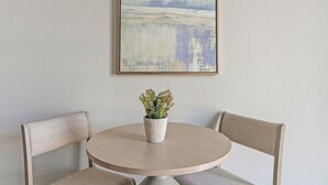 A round table with a potted plant in the center, flanked by two chairs. - Landing | Stunning 1BD in Fountain Heights (Birmingham)