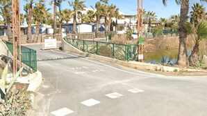 A gated entrance with a sign reading "BLEU MARTINE" and palm trees in the background.