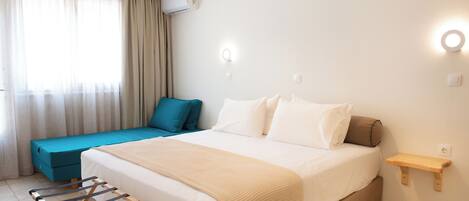 A bedroom with a bed, a bedside table, a wall-mounted shelf, a window with curtains, and an air conditioning unit.