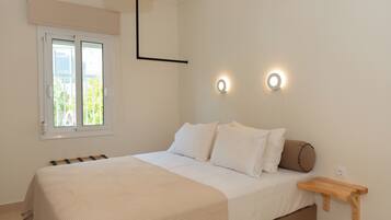 Ein Schlafzimmer mit Bett, Fenster und Nachttisch.
