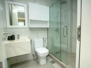 A modern bathroom with a glass-enclosed shower, a white toilet, and a marble-tiled sink. - 2-bedroom apartment in amazing Accra with WiFi, fitness room, AC (Accra)